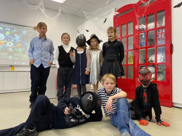 Группа детей в костюмах на бале-маскараде в честь Хеллоуина